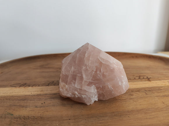 Grande pointe semi-brute quartz rose - vue de face sur plateau bois