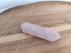 Pointe double terminaison quartz rose fine - vue de face sur plateau bois