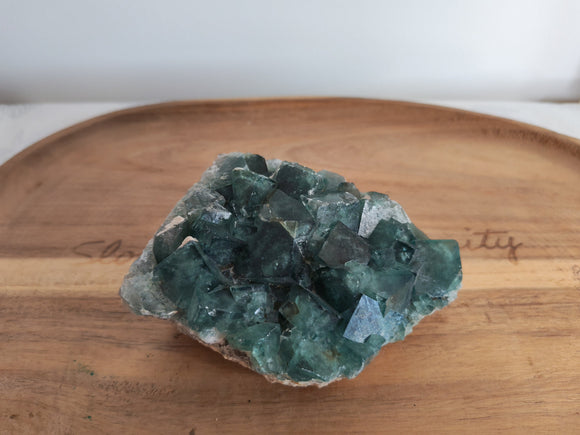 Fluorine brute verte - vue de face sur plateau bois, cristaux cubiques vert-bleu