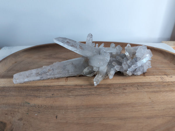 Amas cristal de roche avec pointes - vue de face sur plateau bois