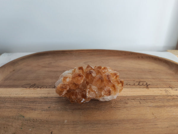 Cluster de citrine brute chauffée - vue de face sur plateau bois