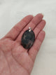 Pendentif ovale agate mousse tenu en main - fond blanc