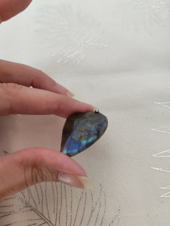 Pendentif cœur labradorite tenu en main - reflets bleus labradorescence