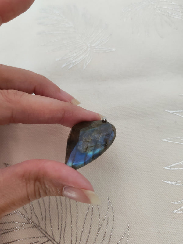 Pendentif cœur labradorite tenu en main - reflets bleus labradorescence
