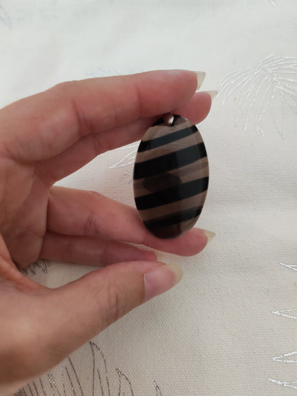 Pendentif obsidienne larme d'apache - tenu en main fond blanc