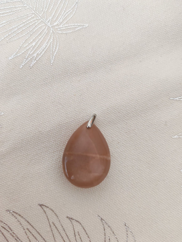 Pendentif larme pierre de soleil - fond tissu blanc bélière argentée