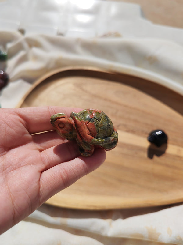 Tortue unakite vert rouge sculptée tenue en main vue de profil