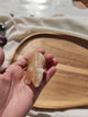Lapin sculpté en aragonite beige-crème tenu en main vue de profil